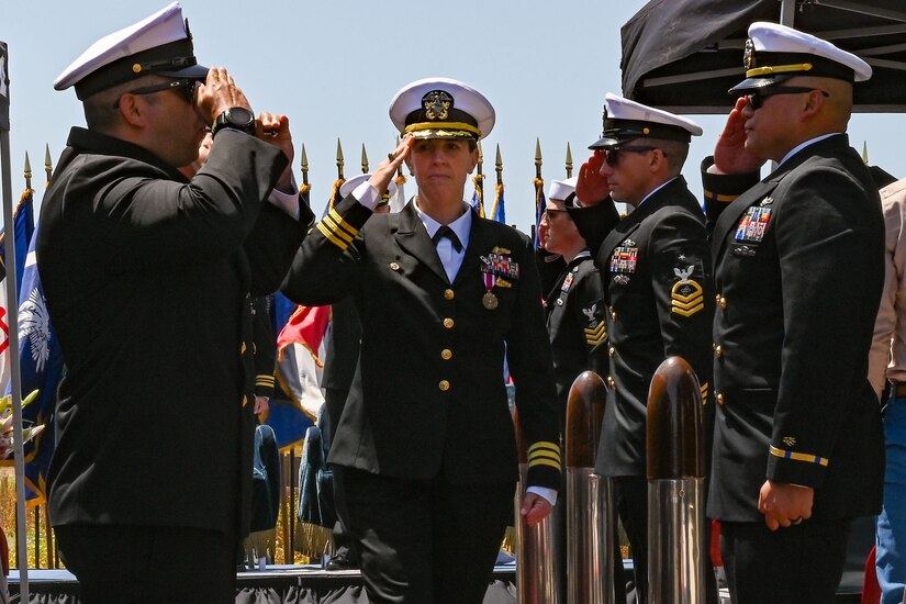 A group of Navy officers salute each other.