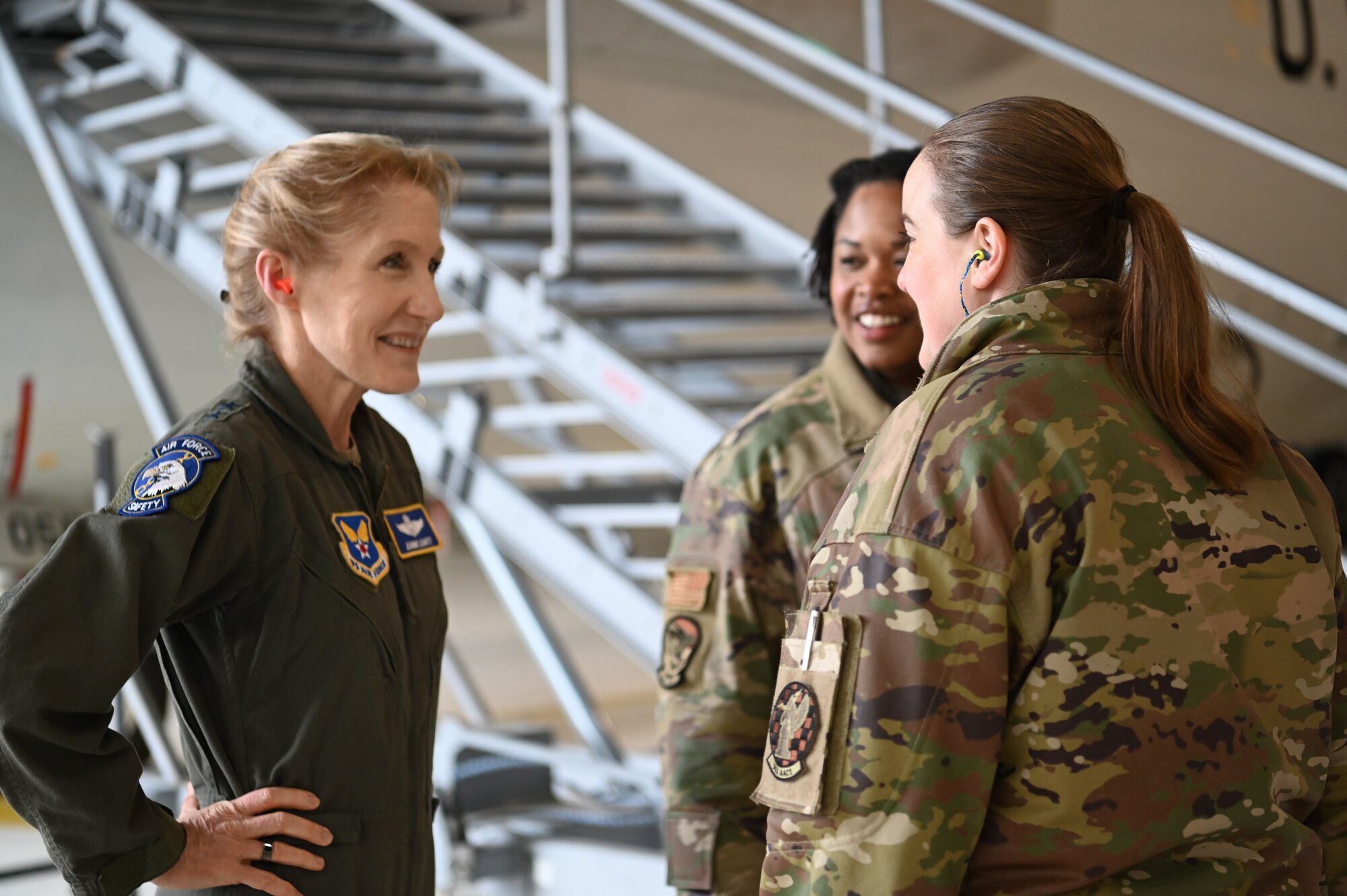 Three female Airmen talking in hangar