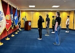 Lt. Cmdr. Iman Parirokh, Chicago MEPS executive officer, leads a group of applicants through the oath of enlistment at Chicago MEPS February 1, 2023.