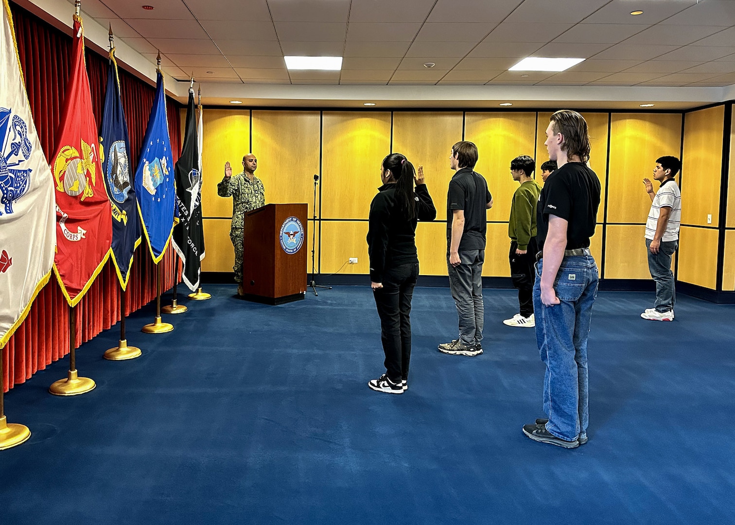 Lt. Cmdr. Iman Parirokh, Chicago MEPS executive officer, leads a group of applicants through the oath of enlistment at Chicago MEPS February 1, 2023.