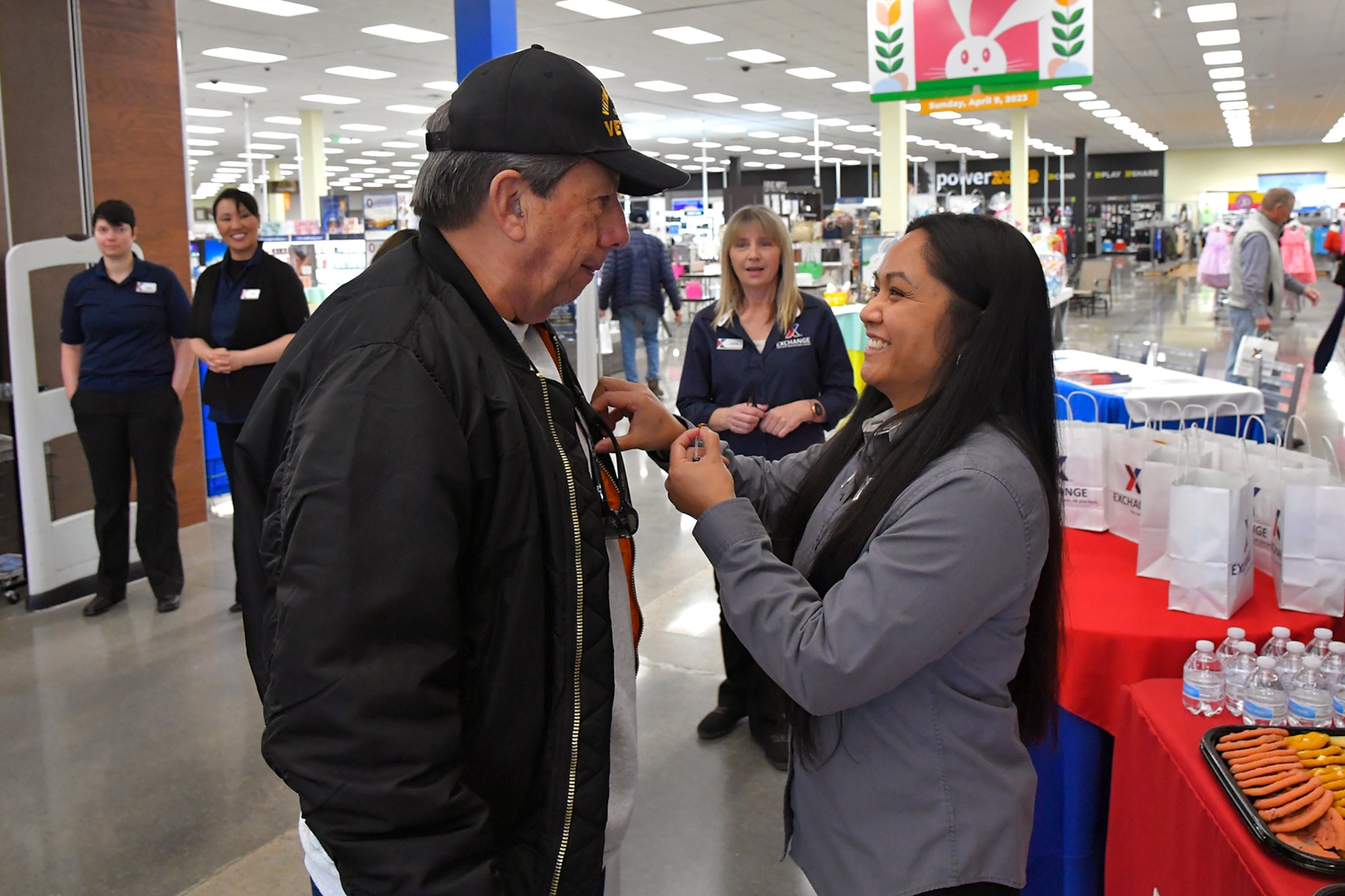 John Ingram, A Vietnam veteran who served in the Air Force, receives a commemorative lapel pin from Eleanor Veloria, AAFES Base Exchange store manager, during a pinning ceremony March 29, 2023, at the AAFES Base Exchange at Hill Air Force Base, Utah. The ceremony was held to honor and remember Vietnam era veterans for National Vietnam Veterans Day. (U.S. Air Force photo by Todd Cromar)
