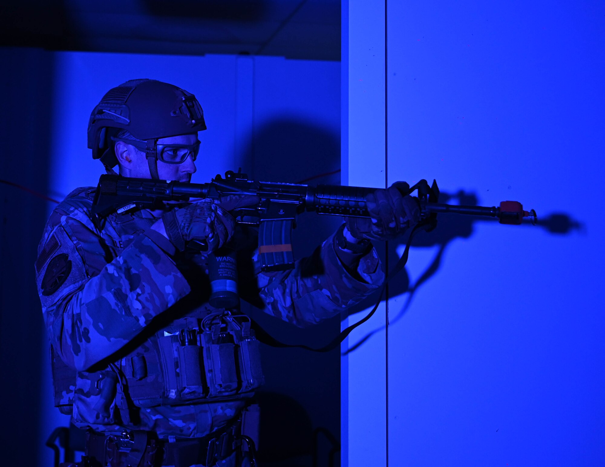 Airman stands guard, holding his weapon at the ready