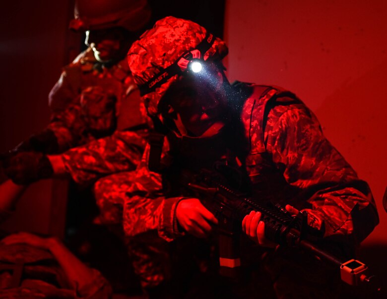 Airman holds weapon at the ready, guarding their team