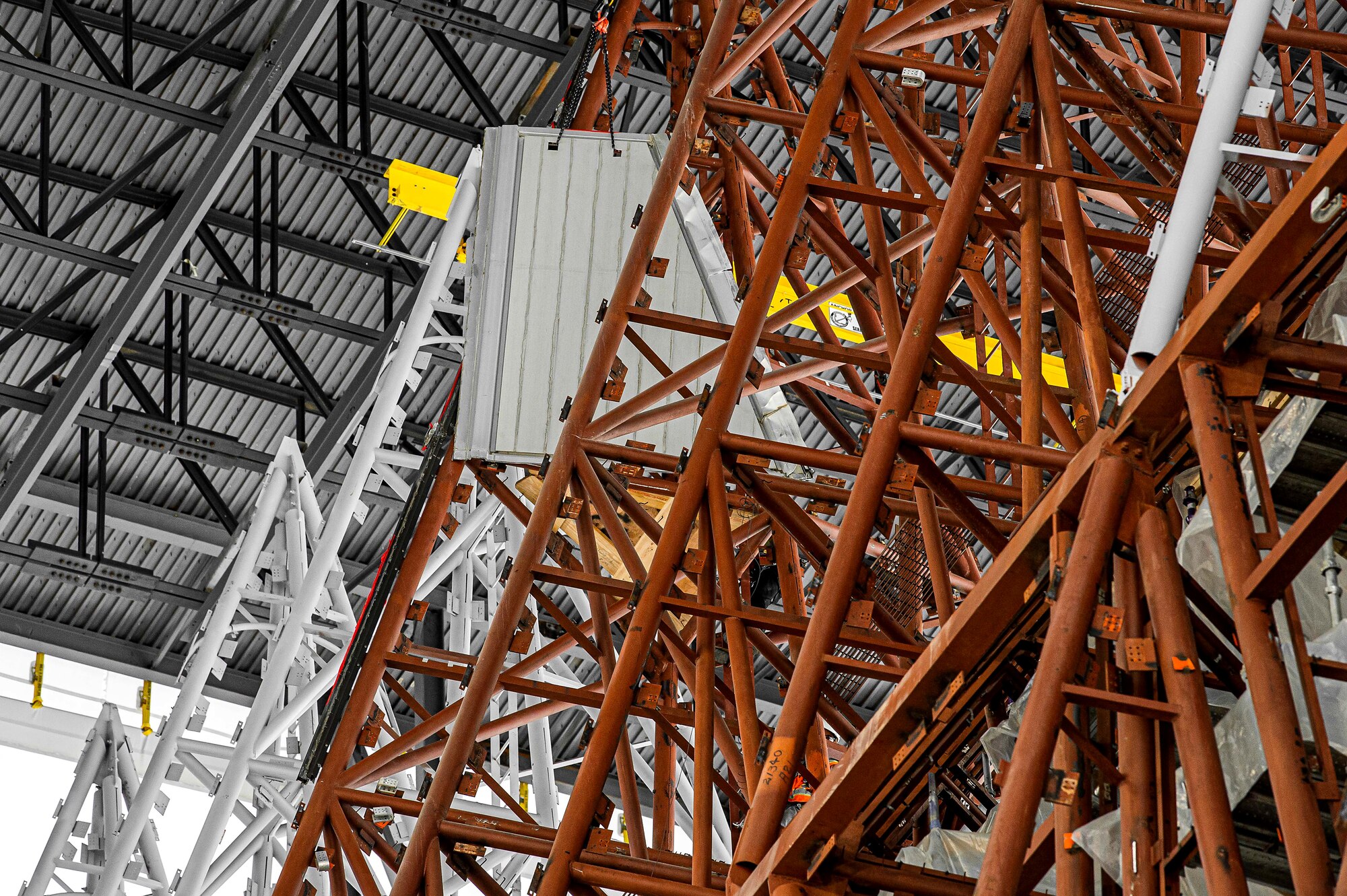 Workers lower the final aluminum piece from the U.S. Air Force Academy's Cadet Chapel using a hoist.