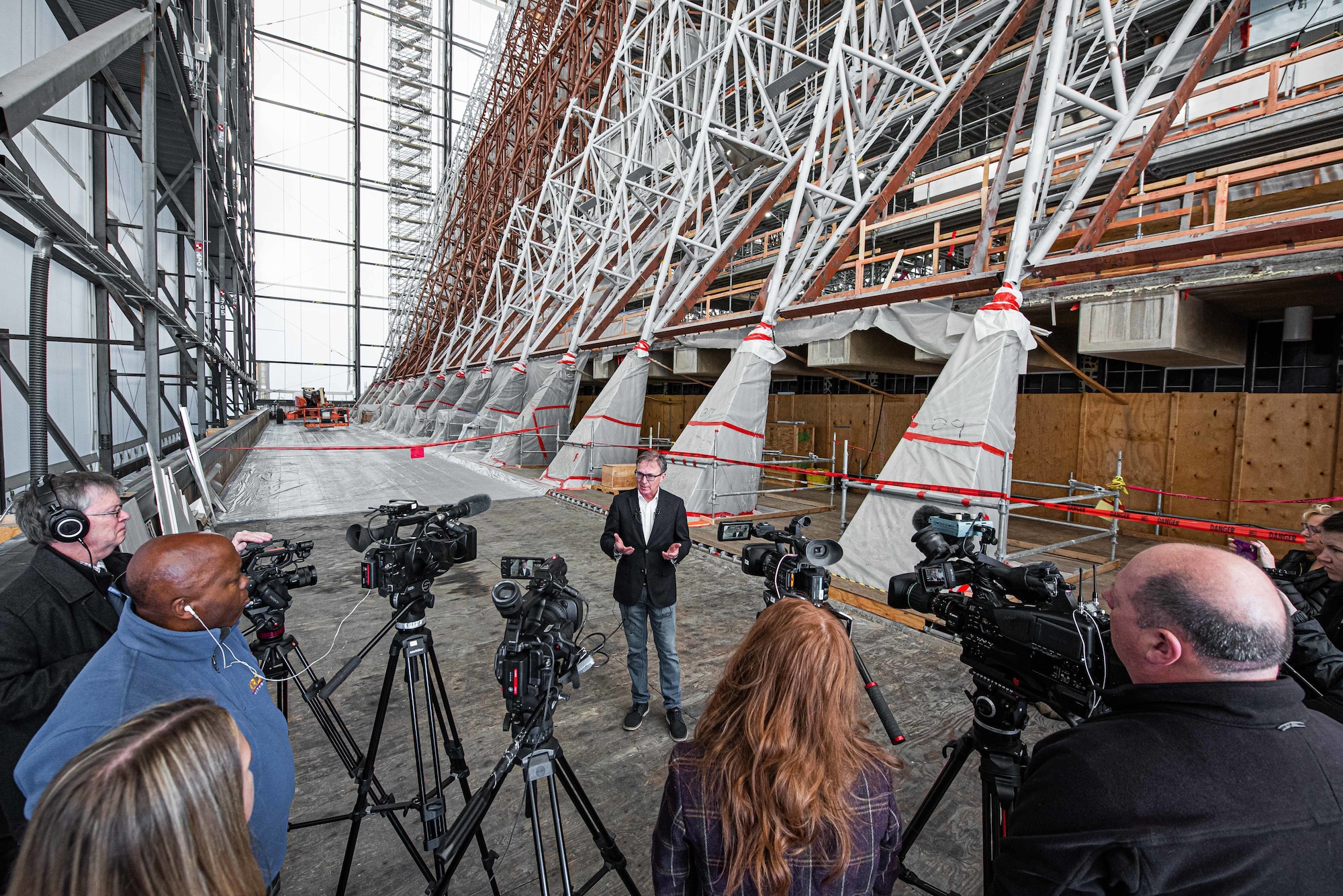 U.S. Air Force Academy architect standing in front of six cameras during a press conference.