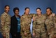 Four women of color in uniform stand together in uniform alongside one in civilian clothes.