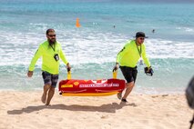 Jonathan Clayton, left, occupational safety health specialist inspector for the Marine Corps Base Hawaii Installation Safety Office, and Mike Horn, facilities maintenance manager for the MCBH ISO, retrieve a remote-controlled lifebuoy during a water safety demonstration, MCBH, March 17, 2023. Maj. Gen. Stephen Liszewski, Commanding General Marine Corps Installation Pacifi, participated in the demonstration during a visit to the base to develop a deeper understanding of the base’s water safety resources and sea rescue capabilities. (U.S. Marine Corps photo by Lance Cpl. Clayton Baker)