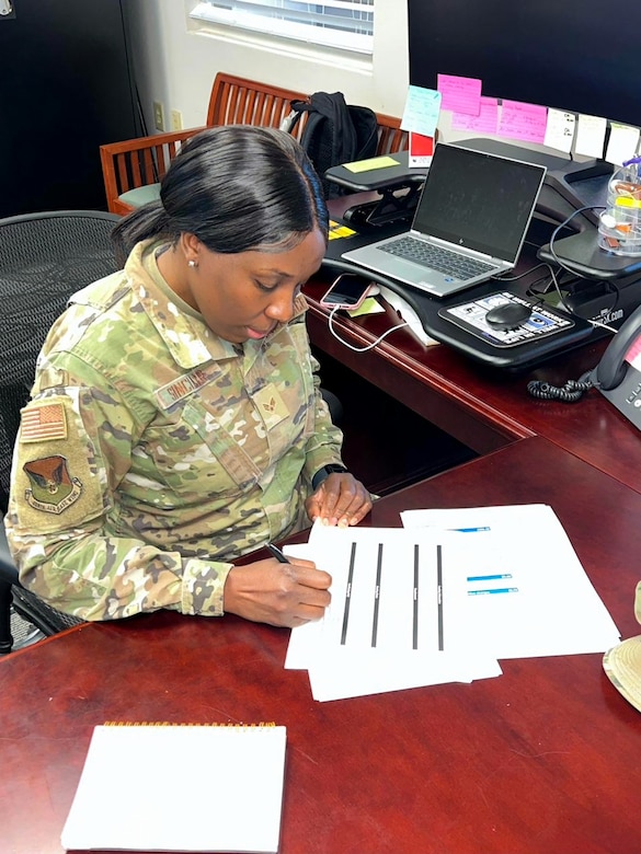 Senior Airman Kenia Sinclair, religious affairs Airman, works on documents at the 628th Air Base Wing Chapel, Joint Base Charleston, S.C., March 26, 2023. Sinclair moved to America in 1999 from Jamaica and joined the U.S. Air Force in 2020 as a way of giving back to the country that made so many of her dreams possible such as competing in four Olympic games. (U.S. Air Force courtesy photo)