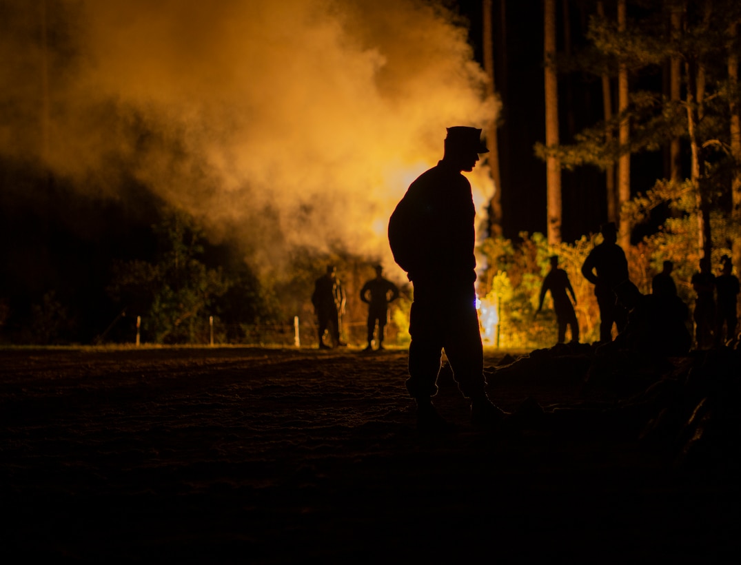 U.S. Marine Corps recruits with Mike Company, 3rd Recruit Training Battalion, conduct the night movement course on Marine Corps Recruit Depot Parris Island, S.C., April 12, 2023. During the night movement course, recruits navigate obstacles through smoke and artillery simulations. (U.S. Marine Corps photo by Pfc. Mary Jenni)