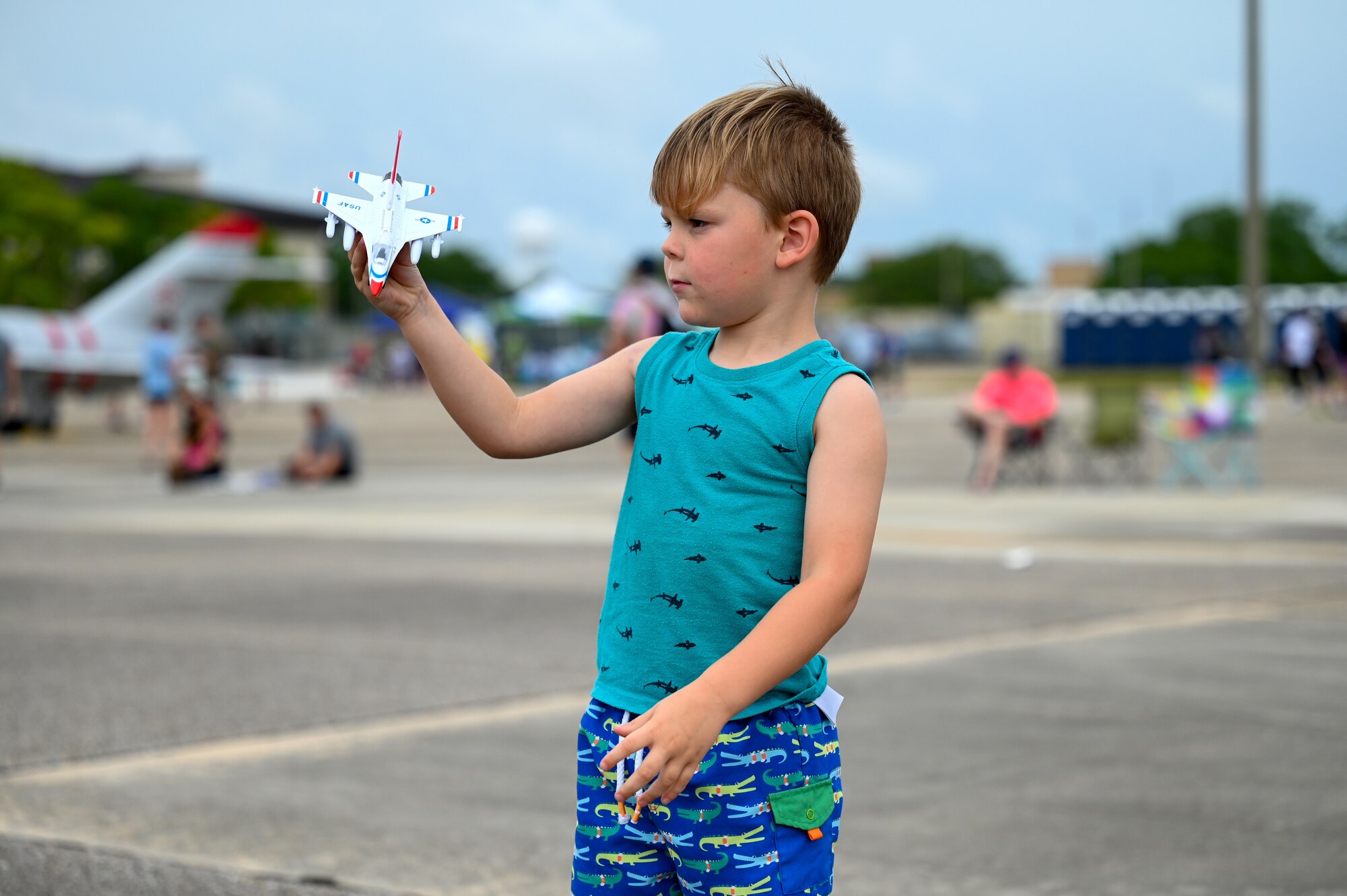 A child plays with a model Thunderbird during the 2023 Thunder Over the Sound Air and Space Show at Keesler Air Force Base, Mississippi, April 29, 2023.