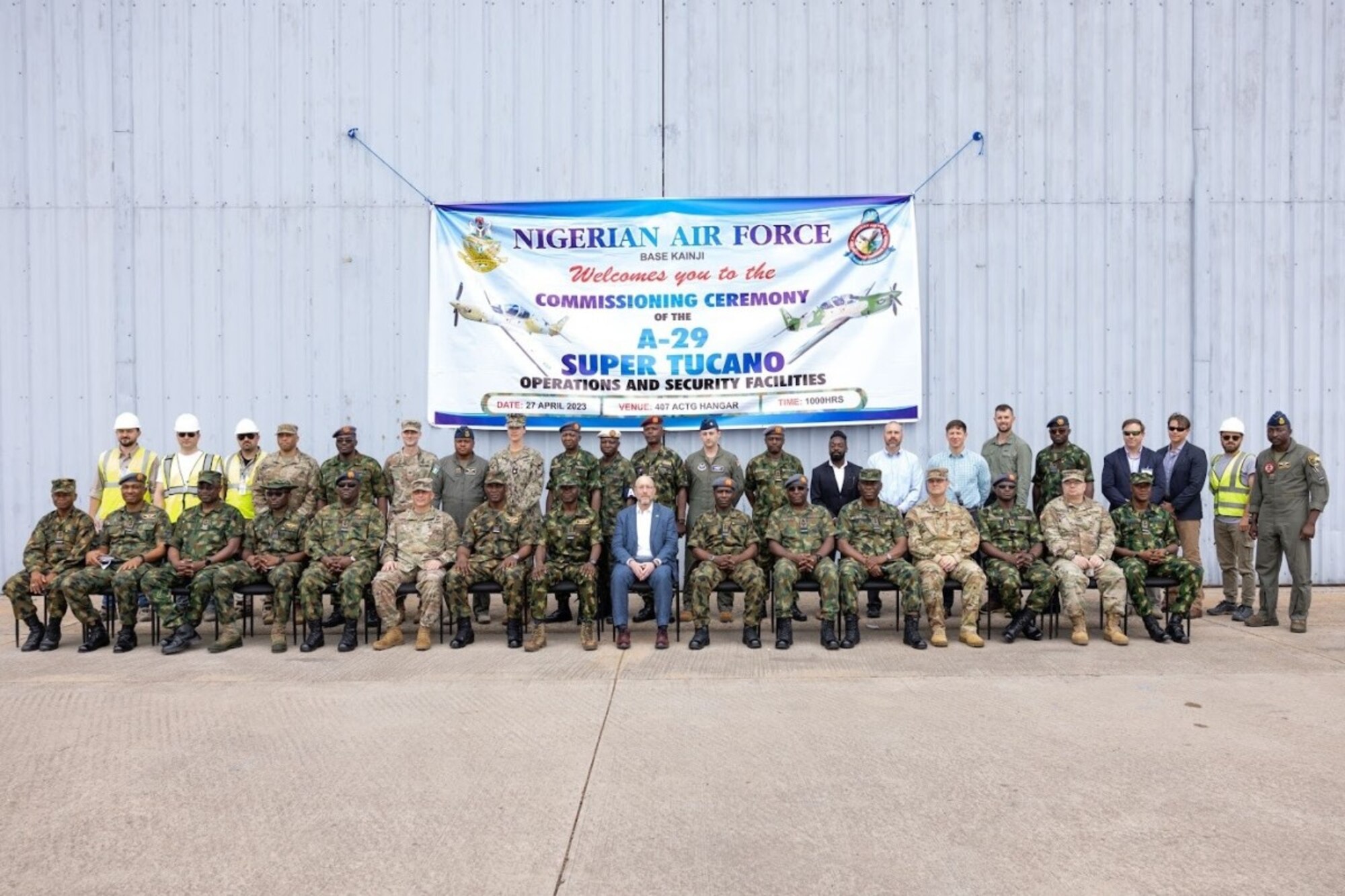 Officials representing the U.S. Embassy in Nigeria, U.S. Army Corps of Engineers, U.S. Air Force Life Cycle Management Center's Air Force Security Assistance and Cooperation Directorate, Nigerian Air Force, contractors and others pose for a picture at Kainji Air Force Base in Nigeria following ceremonies celebrating recently completed base infrastructure improvements there April 27, 2023. They participated in ribbon cutting ceremonies highlighting the completion of several construction projects supporting recently delivered A-29 Super Tucano aircraft. The construction was part of the historic $500 million U.S. foreign military sale to Nigeria, which also includes the delivery of the 12 A-29 Super Tucano aircraft, munitions, and training. (U.S. Embassy in Nigeria photo by Olaoluwa Aworinde)