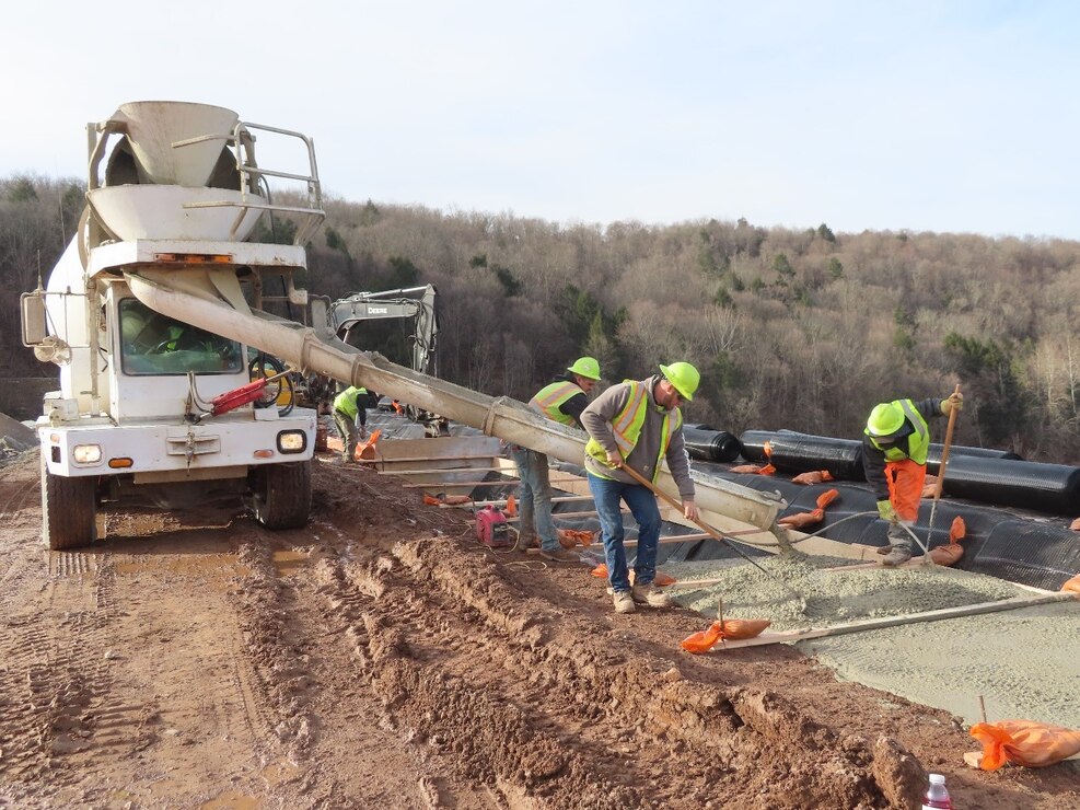 Contractors level and grade concrete at the crest of a dam