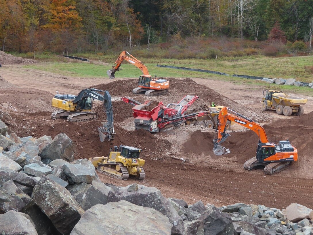 Excavators sort soil and material into multiple piles