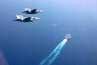 F/A-18F Super Hornets fly in formation above USS Nimitz (CVN 68) in the South China Sea.