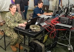 (left to right) Chief Warrant Officer Three Alison Czuhajewski, Navy Expeditionary Combat Command, and Micah Gomez, Joint Expeditionary Command and Control (JEXC2), participate in The Waterside Symposium held at Naval Surface Warfare Center Panama City Division detachment, a JEXC2 test range, April 5. The symposium aimed to showcase the new leading edge Navy Enterprise Tactical Command and Control design that the Navy Lab is developing. (U.S. Navy photo by Ronnie Newsome)