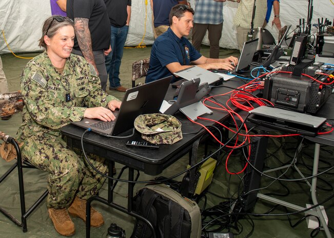 (left to right) Chief Warrant Officer Three Alison Czuhajewski, Navy Expeditionary Combat Command, and Micah Gomez, Joint Expeditionary Command and Control (JEXC2), participate in The Waterside Symposium held at Naval Surface Warfare Center Panama City Division detachment, a JEXC2 test range, April 5. The symposium aimed to showcase the new leading edge Navy Enterprise Tactical Command and Control design that the Navy Lab is developing. (U.S. Navy photo by Ronnie Newsome)