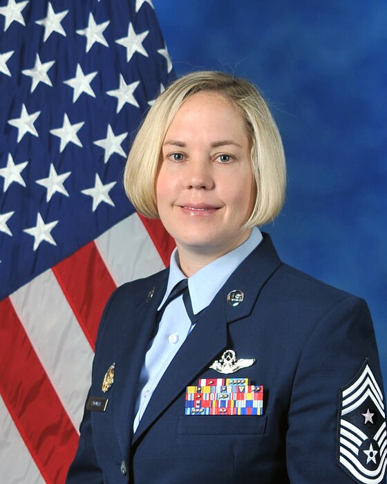 Official photo for 363d ISR Wing Command Chief in front of U.S. Flag.