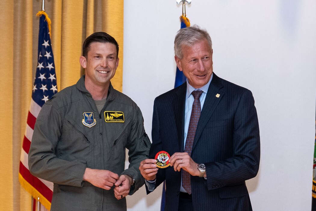 Lt. Col. Christopher McConnell, 37th Bomb Squadron commander, left, and Mr. Lance Fritz, U.S. Strategic Command Consultation Committee member, exchange a patch and coin during the Omaha Trophy presentation ceremony at Ellsworth Air Force Base, South Dakota, April 21, 2023. Only the commanders of units who have won the Omaha Trophy can receive the Strategic Command Consultation Committee coin; it recognizes the leadership traits required to lead an exceptional unit. (U.S. Air Force photo by Senior Airman Alexis M. Morris)