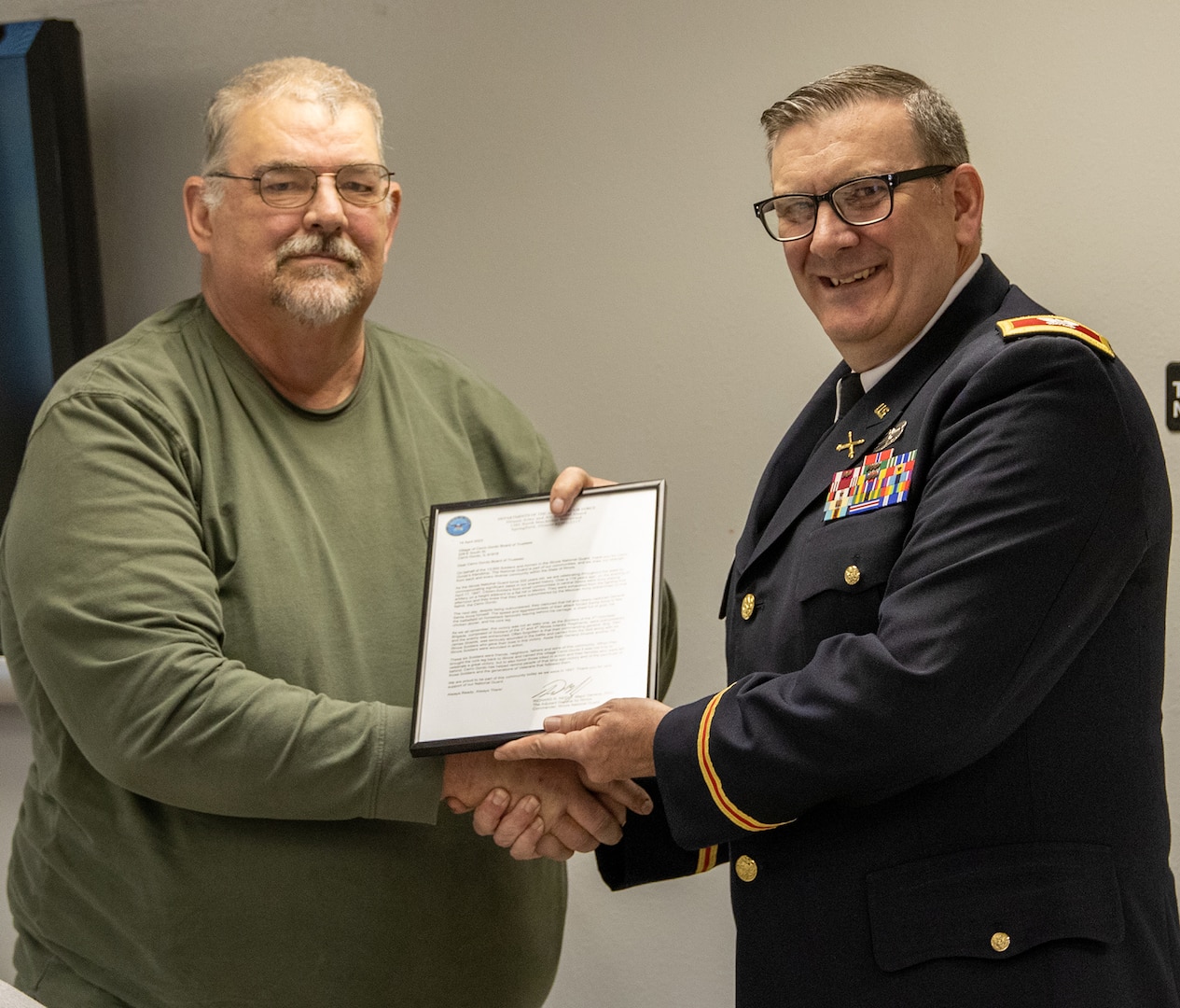 Col. Lenny Williams, Chief of Staff, Illinois Army National Guard, presents a framed letter from Maj. Gen. Rich Neely, the Adjutant General of Illinois, and Commander of the Illinois National Guard, to Cerro Gordo Village President Pro-Tem Jeff Power, and the Village of Cerro Gordo Board of Trustees, during a presentation April 17.