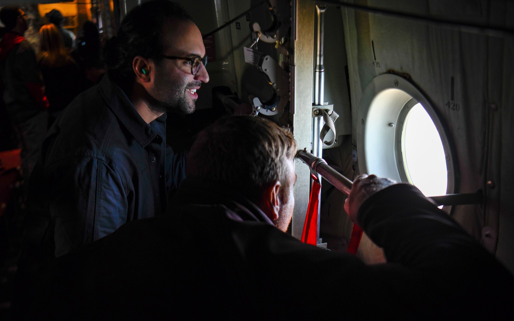 Seth Basista, a teacher with STEM Academy, and Dustin Cramer, a teacher with Canfield STEM, look out the window of a C-130H Hercules aircraft assigned to the 910th Airlift Wing en route to Niagara Falls, April 27, 2023.