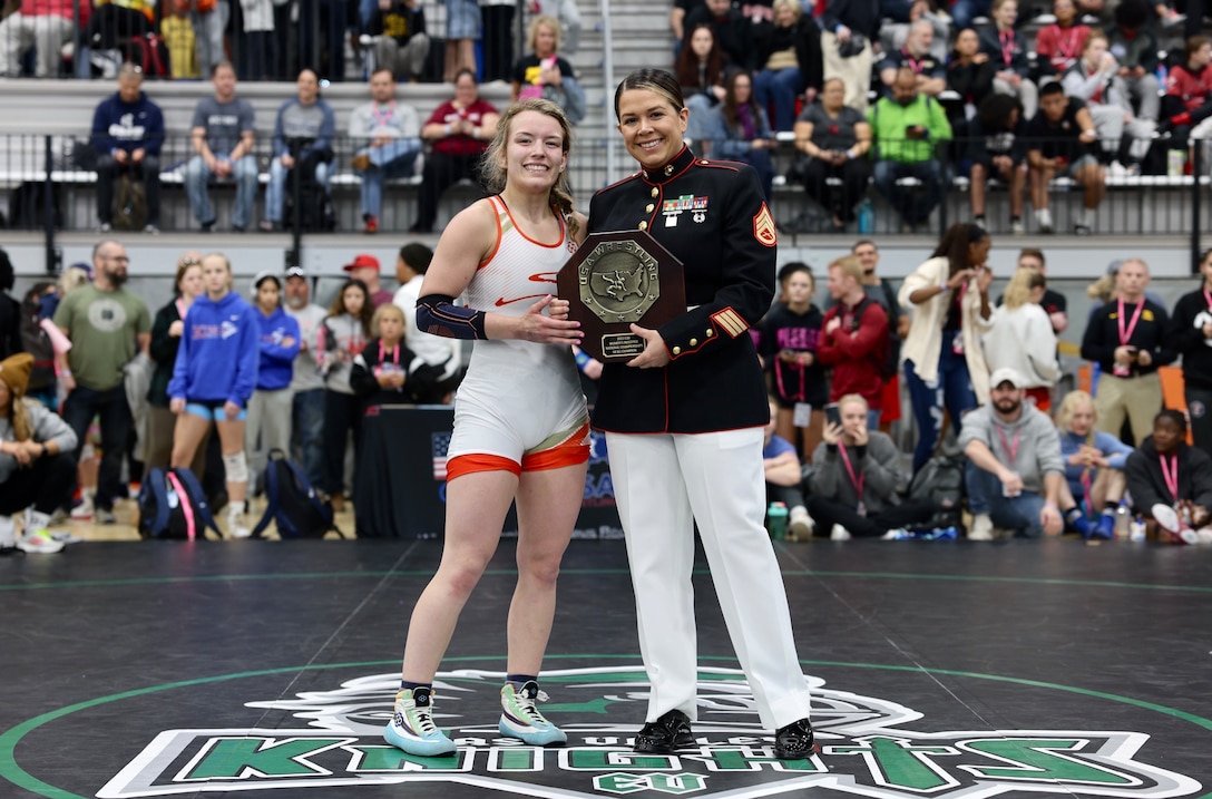 U.S. Marine Corps Staff Sgt. Courtney White, a combat videographer with I Marine Information Group, I Marine Expeditionary Force, presents a first-place award (U17) to the National Champion at the USA Women’s Wrestling Nationals tournament in Spokane, Wash., April 15, 2023. The Marine Corps’ partnership with USA Wrestling started in 2017 as a way for Marines to develop new relationships with wrestling coaches. These partnerships ensure the coaches of the next generation of Marines are aware of Marine Corps opportunities, provide advocacy and support recruiter access to prospective audiences, which is critical to our nation's defense. White is a native of Chula Vista, Calif. (U.S. Marine Corps photo by Cpl. Levi Voss)