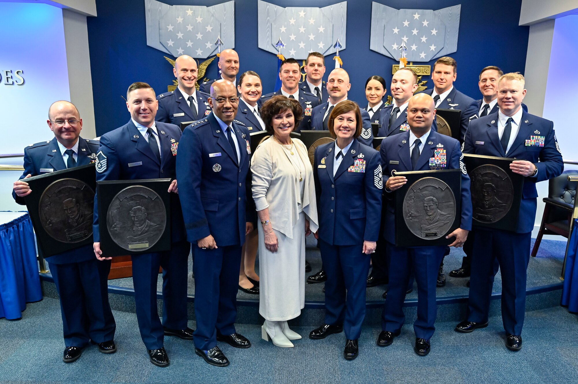 Individuals pose for a group photo with their awards.