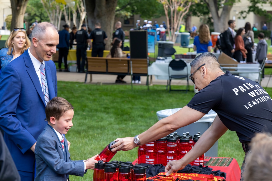 U.S. Marine Corps Master Gunnery Sgt. Michael Abragan, the operations chief with Marine Corps Recruiting Command, gives a water bottle to a child attending the Pentagon’s “Bring Your Child to Work Day” in Arlington, Va., on April 27, 2023. MCRC attended the event to further foster among today’s youth an understanding of the value of service, including: opportunities to serve the needs of others, opportunities to defend the freedoms we hold dear, and opportunities to make a positive impact on the world. (U.S. Marine Corps photo by Cpl. Levi Voss)