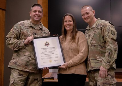 Rachel Golden (center), spouse of retiring Command Sgt. Maj. Brandon Golden, of Easton, Illinois, is presented a certificate of appreciation by Lt. Col. Wyatt Bickett, deputy commander, 129th Regiment (Regional Training Institute), during a retirement ceremony April 23 at the Illinois Military Academy on Camp Lincoln, Springfield, Illinois.