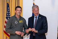 Lt. Col. Christopher McConnell, 37th Bomb Squadron commander, left, and Mr. Lance Fritz, U.S. Strategic Command Consultation Committee member, exchange a patch and coin during the Omaha Trophy presentation ceremony at Ellsworth Air Force Base, South Dakota, April 21, 2023. Only the commanders of units who have won the Omaha Trophy can receive the Strategic Command Consultation Committee coin; it recognizes the leadership traits required to lead an exceptional unit. (U.S. Air Force photo by Senior Airman Alexis M. Morris)