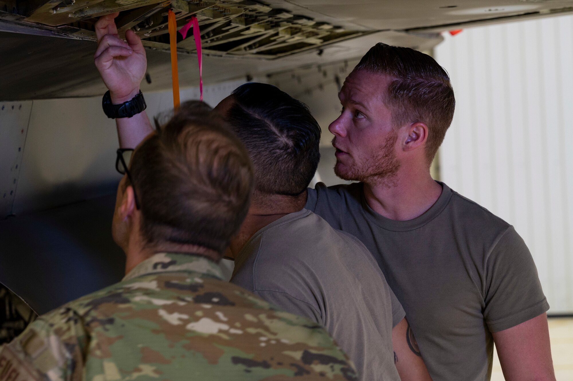 U.S. Air Force Tech. Sgt. Travis Ellsworth, 49th Component Maintenance Squadron aircraft fuels systems craftsman, right, inspects a leak before shift change at Holloman Air Force Base, New Mexico, April 26, 2023.