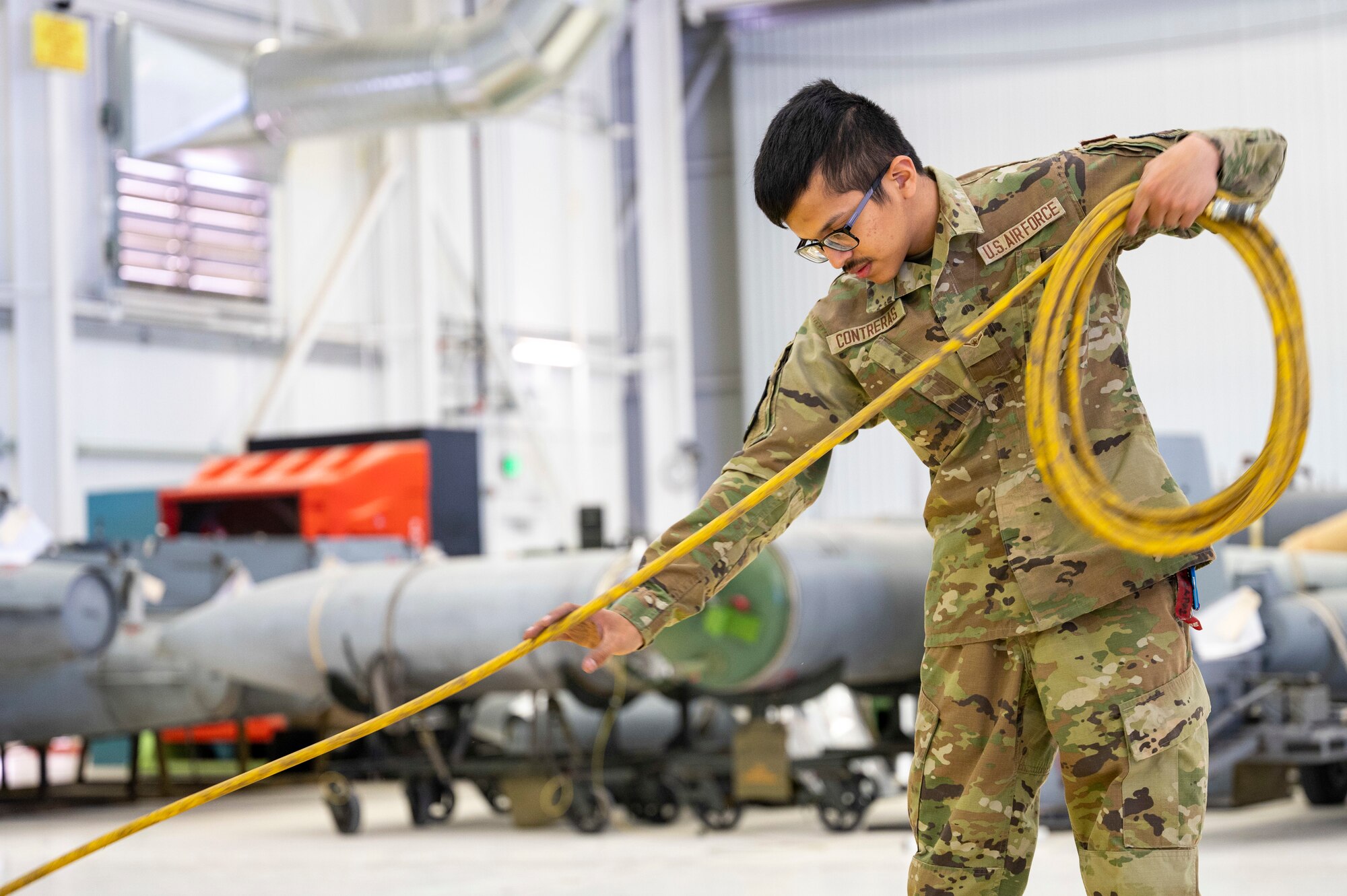 U.S. Air Force Airman 1st Class Sergio Contreras, 49th Component Maintenance Squadron aircraft fuels systems journeyman, wraps up an air hose at Holloman Air Force Base, New Mexico, April 26, 2023.