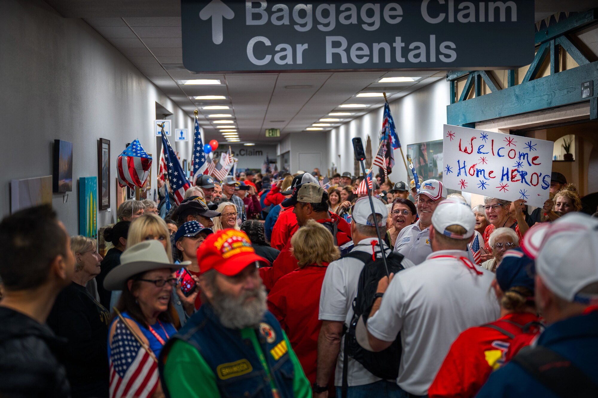WWII, Korea and Vietnam veterans of the California Central Coast Coastal Honor Flight are cheered on by attendees as walk through the Santa Maria Airport in Santa Maria, Calif., April 26, 2023. More than 1,000 attendees showed up to support the event including family members, friends, military personnel and local residents. (U.S. Space Force photo by Tech. Sgt. Luke Kitterman)