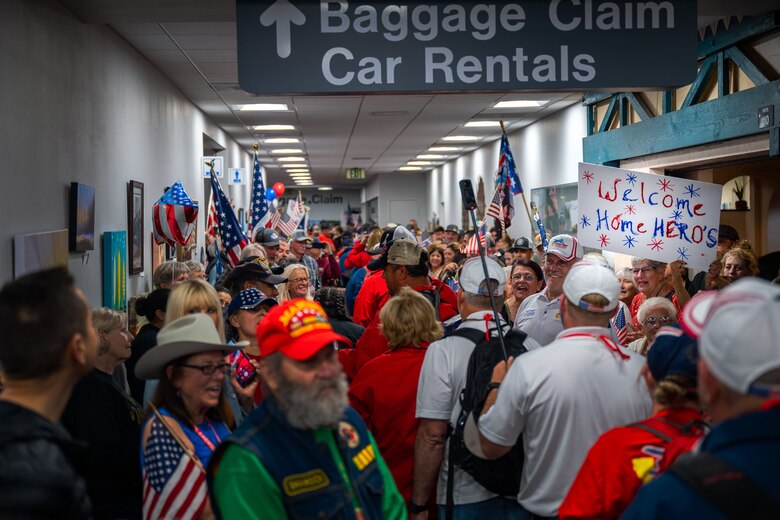 WWII, Korea and Vietnam veterans of the California Central Coast Coastal Honor Flight are cheered on by attendees as walk through the Santa Maria Airport in Santa Maria, Calif., April 26, 2023. More than 1,000 attendees showed up to support the event including family members, friends, military personnel and local residents. (U.S. Space Force photo by Tech. Sgt. Luke Kitterman)