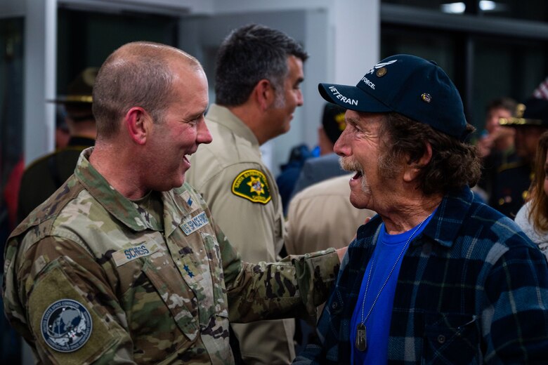 U.S. Space Force Maj. Gen. Douglas A. Schiess, Combined Force Space Component Command commander, left, shares a smile with a veteran of the California Central Coast Coastal Honor Flight at the Santa Maria Airport in Santa Maria, Calif., April 26, 2023. More than 1,000 attendees showed up to support the event including family members, friends, military personnel and local residents. (U.S. Space Force photo by Tech. Sgt. Luke Kitterman)
