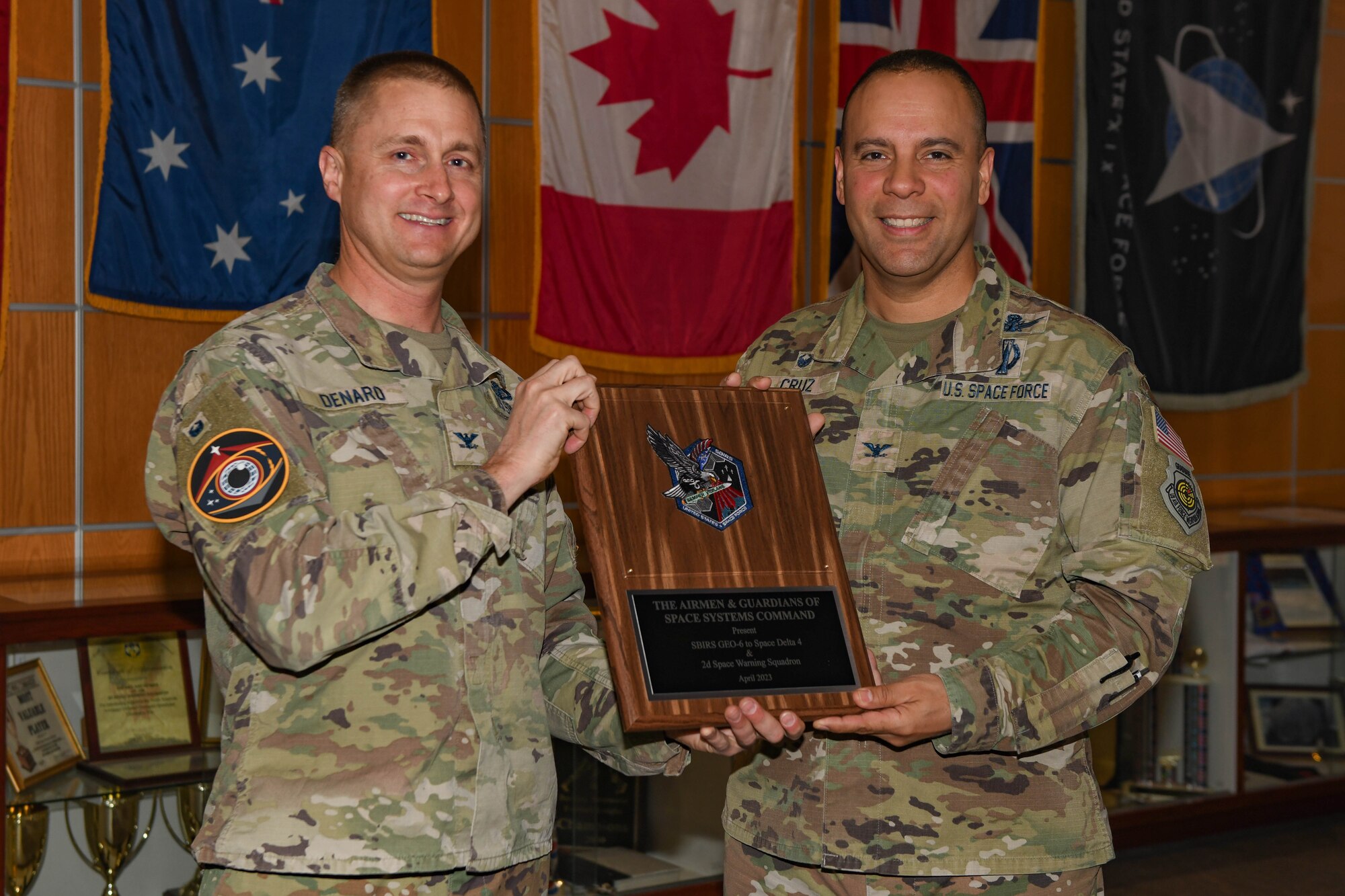 Two men pose for a photo with a plaque.