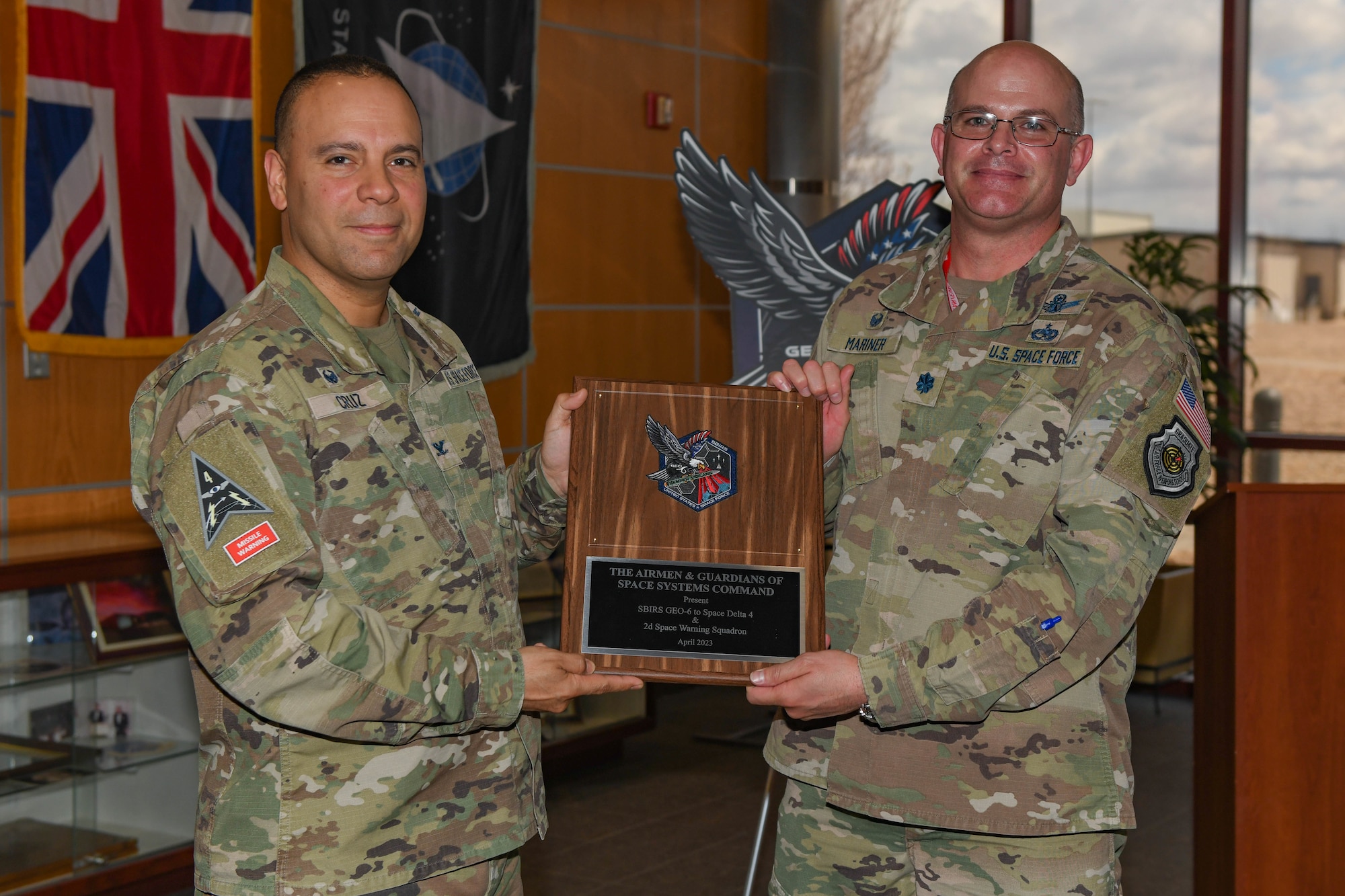 Two men pose for a photo with a plaque.