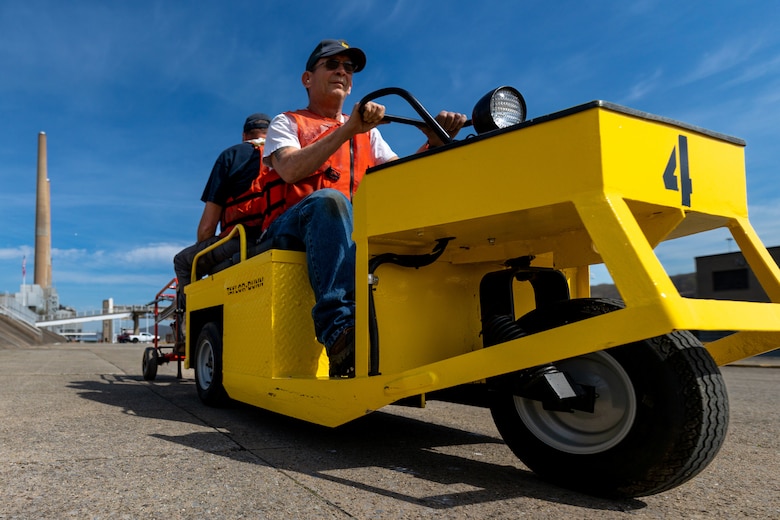 A man drives a cart along a lock wall.