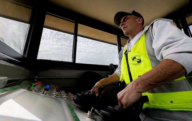 A man operators a switchboard to open a lock gate.