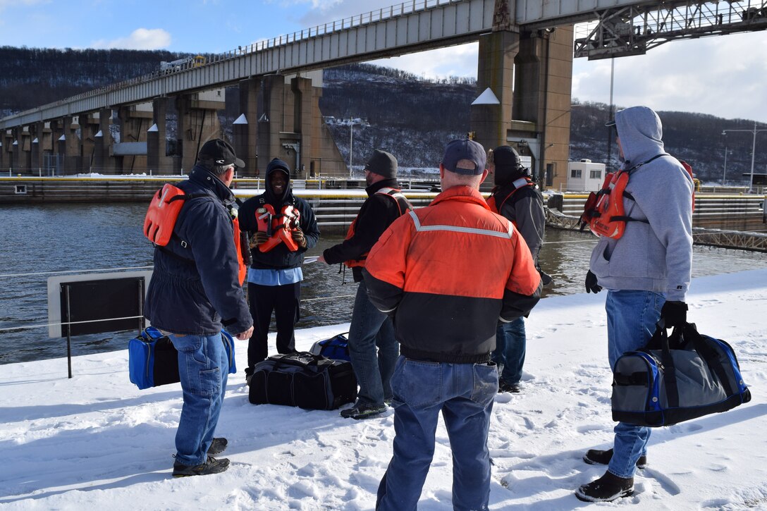 Archived photo. Men stand on a lock wall during the winter months.