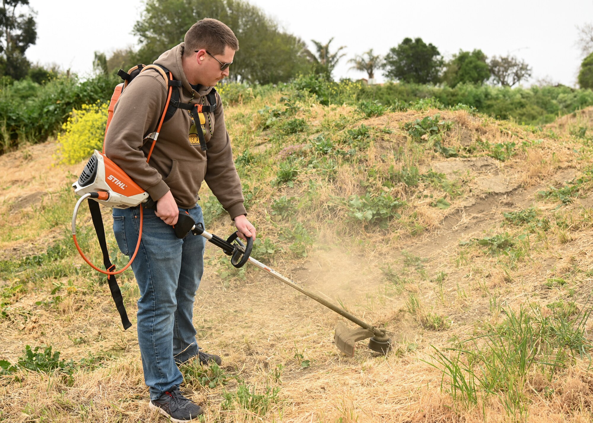A member of Vandenberg's 30th Civil Engineer Squadron volunteers at the River Bend Bike Park in Lompoc, Calif., April 28, 2023. The member used trimmers to weed whack all of the unwanted weeds to help beautify the park. (U.S. Space Force photo by Senior Airman Tiarra Sibley)