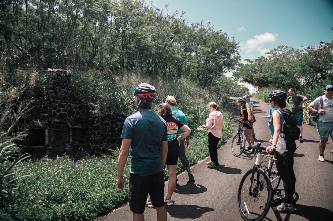 Participants view remnants of a 1930s cottage foundation during the third stop on the Mokapu Cultural Sites Bike Tour, Marine Corps Base Hawaii, April 22, 2023. June Cleghorn, MCBH Environmental Compliance and Protection Division Cultural Resource Manager, led a tour while informing participants of the protected cultural sites and historic significance of the MCBH Mokapu Peninsula. (U.S. Marine Corps photo by Cpl. Christian Tofteroo)