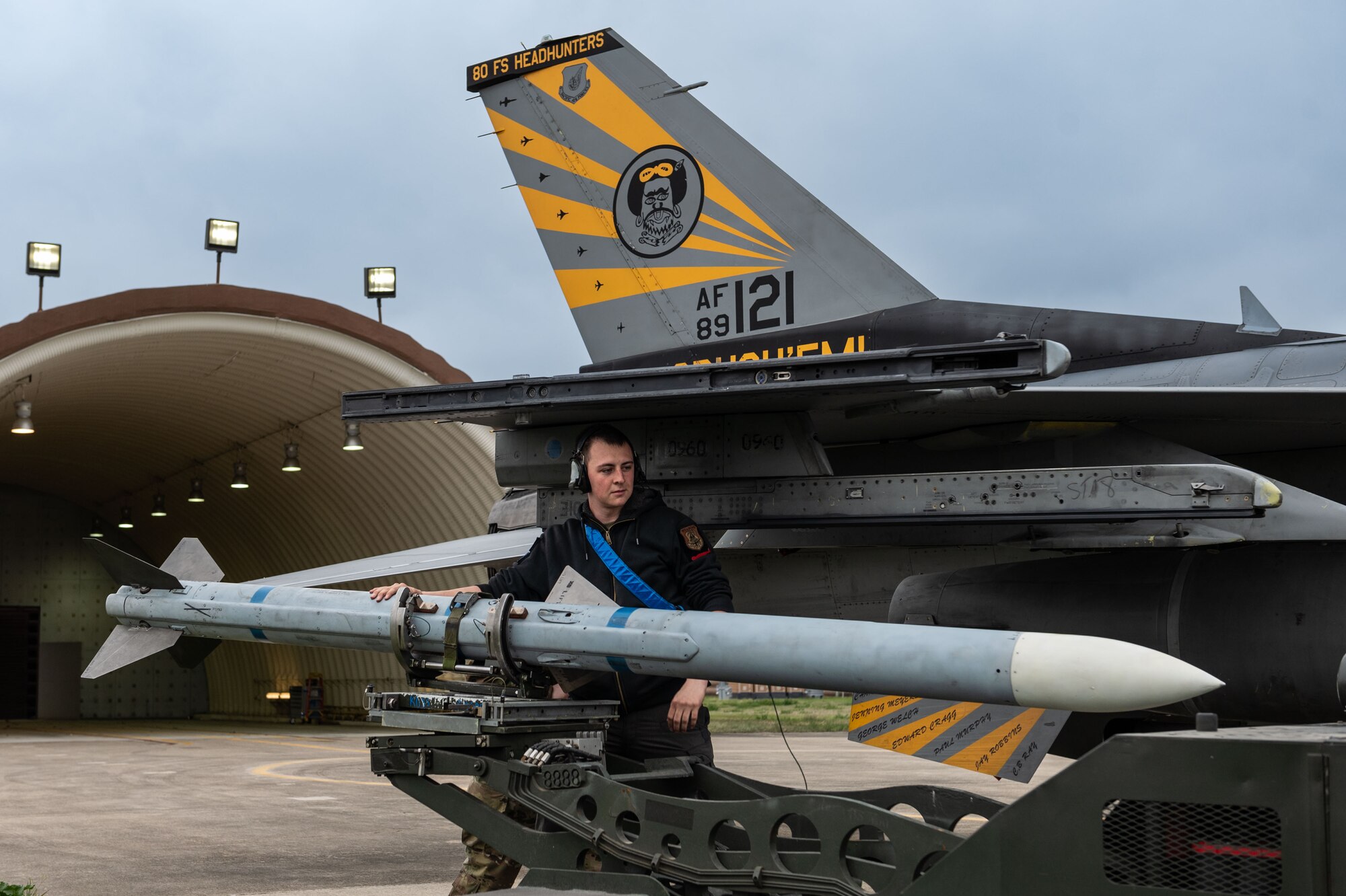 A wide shot of a maintainer with a large munition