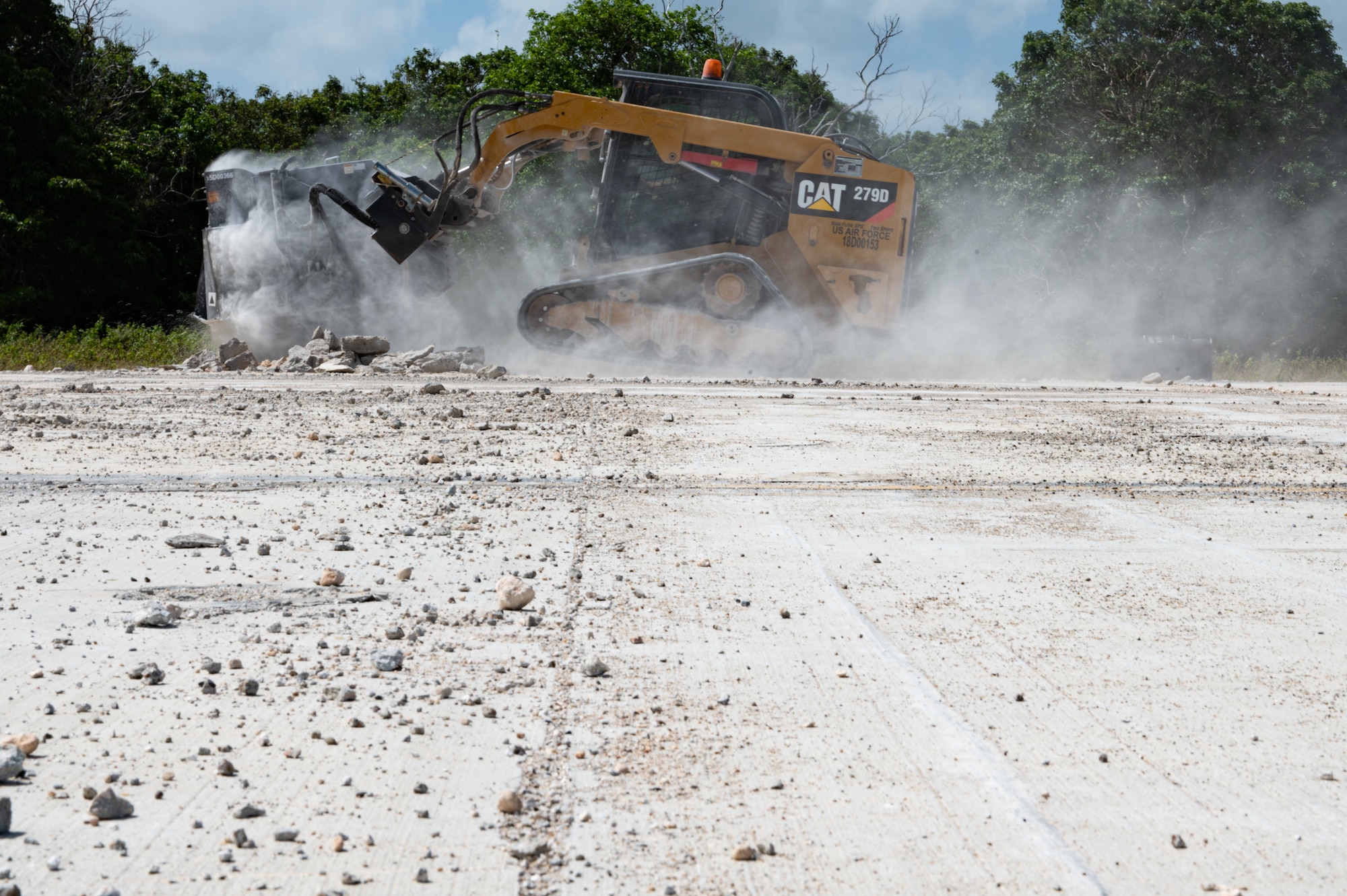 A 36th Civil Engineer Squadron Airman uses a compact track loader with a concrete saw attachment to cut concrete during an expedient and expeditionary airfield damage repair demonstration hosted by Headquarters Pacific Air Forces Civil Engineer Division at the Pacific Regional Training Center-Andersen, Guam, April 20, 2023. Sixteen Airmen from the 36th CES were provided two days of vehicle and material familiarization from the 554th Rapid Engineer Deployable Heavy Operational Repair Squadron Engineers and the Air Force Civil Engineer Center to complete airfield damage repair using the smaller packages of Airmen and equipment, called E-ADR. They used their familiarization to validate the E-ADR concept, in support of a Pacific Air Forces agile combat employment, repairing 10 craters with a lighter and leaner vehicle and equipment kit that weighs a fraction of a standard Rapid Airfield Damage Recovery package. (U.S. Air Force photo by Staff Sgt. Suzie Plotnikov)