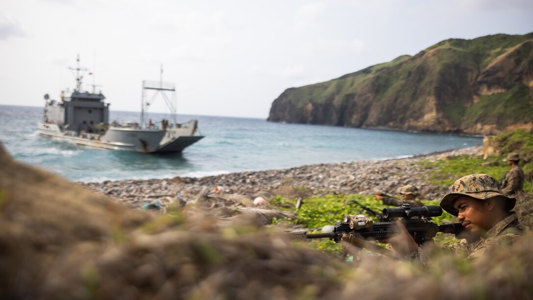 U.S. Marines with 3d Littoral Combat Team, 3d Marine Littoral Regiment, 3d Marine Division, secure a landing zone for a U.S. Army landing craft, utility, assigned to 10th Regional Support Group, transporting a High Mobility Artillery Rocket System assigned to 1st Multi-Domain Task Force, during a joint, bilateral, littoral campaign as part of Balikatan 23 on Basco, Philippines, April 24, 2023. The littoral campaign took place over three days, during which the joint and bilateral force secured key maritime terrain on three islands in the Luzon Strait. Balikatan 23 is the 38th iteration of the annual bilateral exercise between the Armed Forces of the Philippines and the U.S. military. The exercise includes three weeks of training focused on amphibious operations, command and control, humanitarian assistance, urban operations and counterterrorism skills throughout northern and western Luzon. Coastal defense training figures prominently in the Balikatan 23 training schedule. (U.S. Marine Corps photo by Sgt. Patrick King)