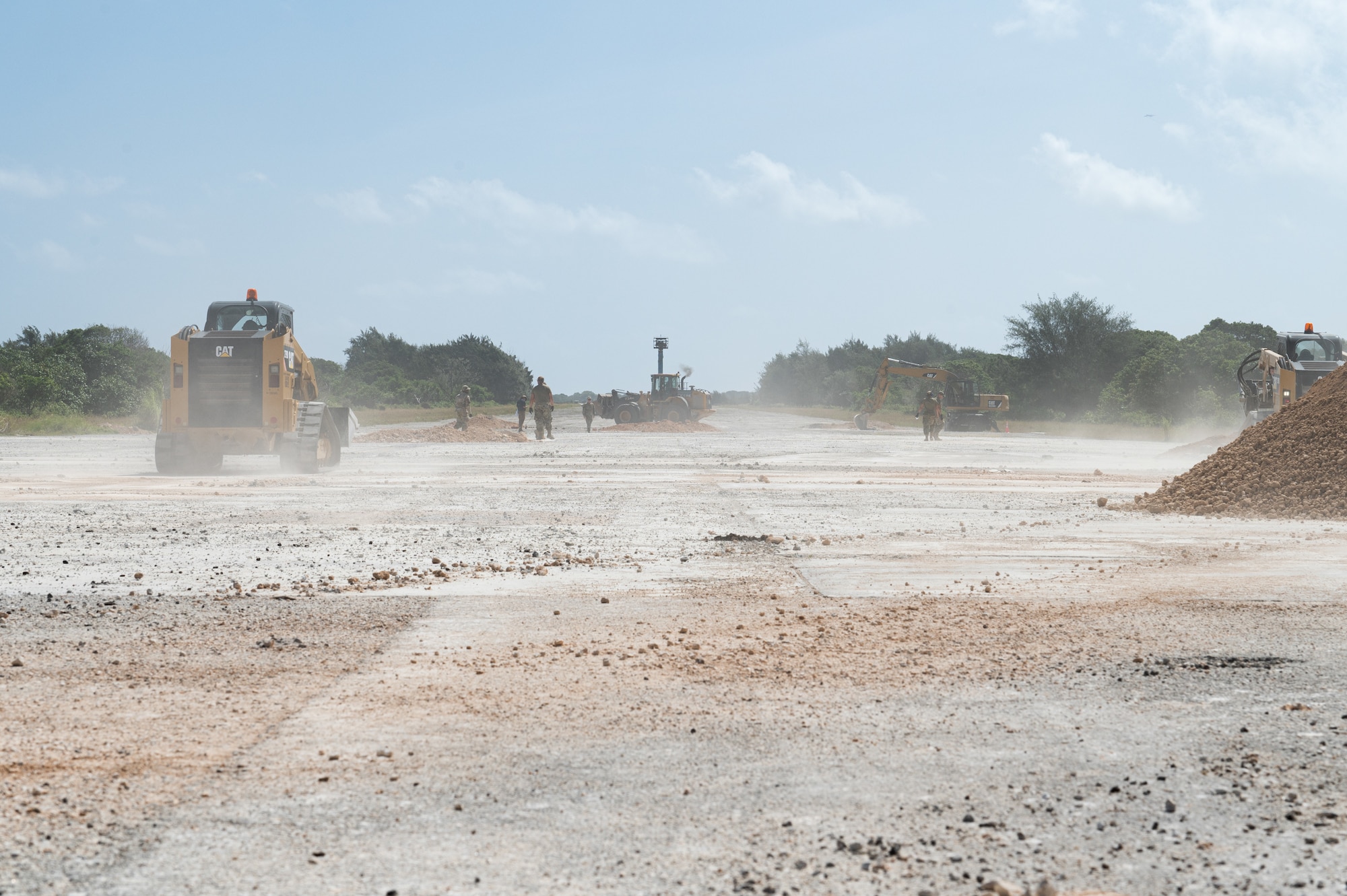 Airmen from the 36th Civil Engineer Squadron repair a runway during an expedient and expeditionary airfield damage repair demonstration hosted by Headquarters Pacific Air Forces Civil Engineer Division at the Pacific Regional Training Center-Andersen, Guam, April 20, 2023. Sixteen Airmen from the 36th CES were provided two days of vehicle and material familiarization from the 554th Rapid Engineer Deployable Heavy Operational Repair Squadron Engineers and the Air Force Civil Engineer Center to complete airfield damage repair using the smaller packages of Airmen and equipment, called E-ADR. They used their familiarization to validate the E-ADR concept, in support of Pacific Air Forces Agile Combat Employment, repairing 10 craters with a lighter and leaner vehicle and equipment kit that weighs a fraction of a standard Rapid Airfield Damage Recovery package. (U.S. Air Force photo by Staff Sgt. Suzie Plotnikov)