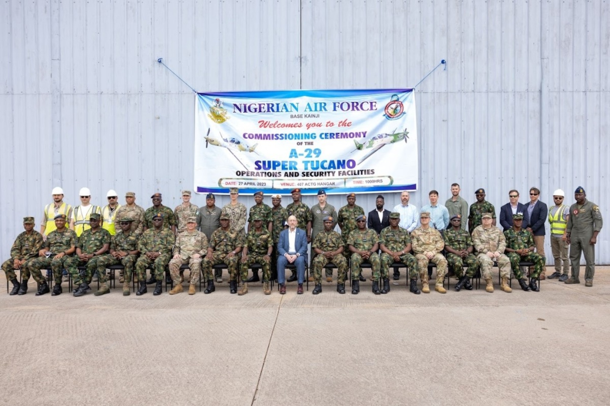 Officials representing the U.S. Embassy in Nigeria, U.S. Army Corps of Engineers, U.S. Air Force Life Cycle Management Center's Air Force Security Assistance and Cooperation Directorate, Nigerian Air Force, contractors and others pose for a picture at Kainji Air Force Base in Nigeria following ceremonies celebrating recently completed base infrastructure improvements there April 27, 2023. They participated in ribbon cutting ceremonies highlighting the completion of several construction projects supporting recently delivered A-29 Super Tucano aircraft. The construction was part of the historic $500 million U.S. foreign military sale to Nigeria, which also includes the delivery of the 12 A-29 Super Tucano aircraft, munitions, and training. (U.S. Embassy in Nigeria photo by Olaoluwa Aworinde)