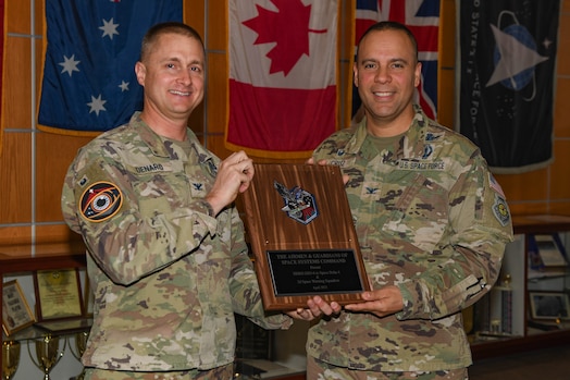  Two men pose for a photo with a plaque.