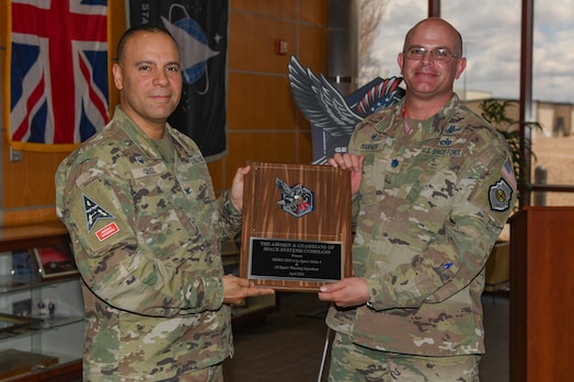  Two men pose for a photo with a plaque.