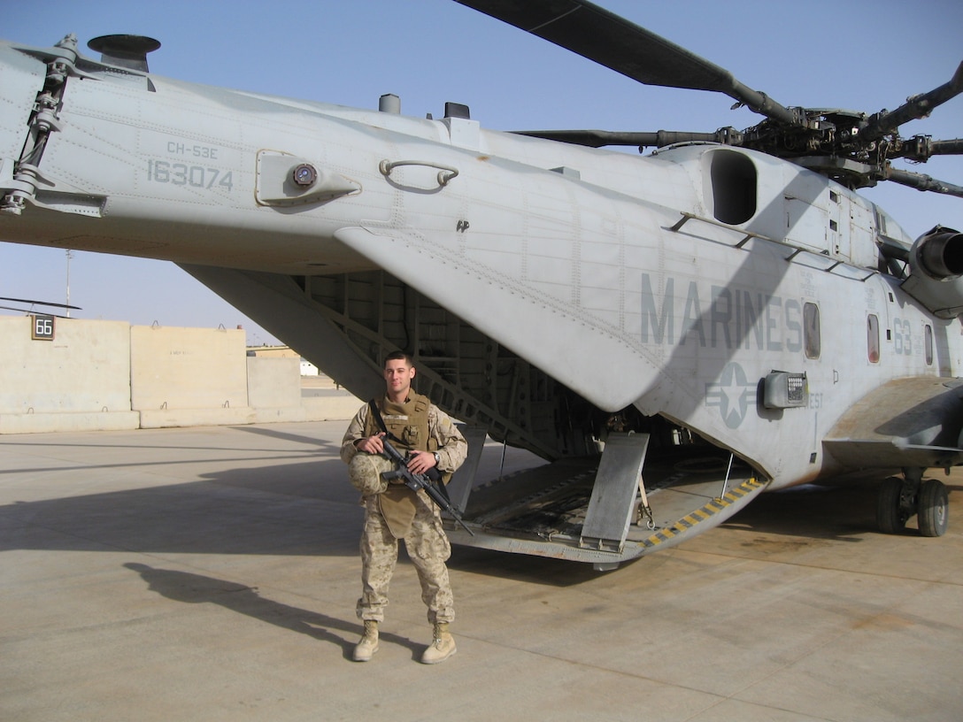 Man in military uniform standing outside of aircraft