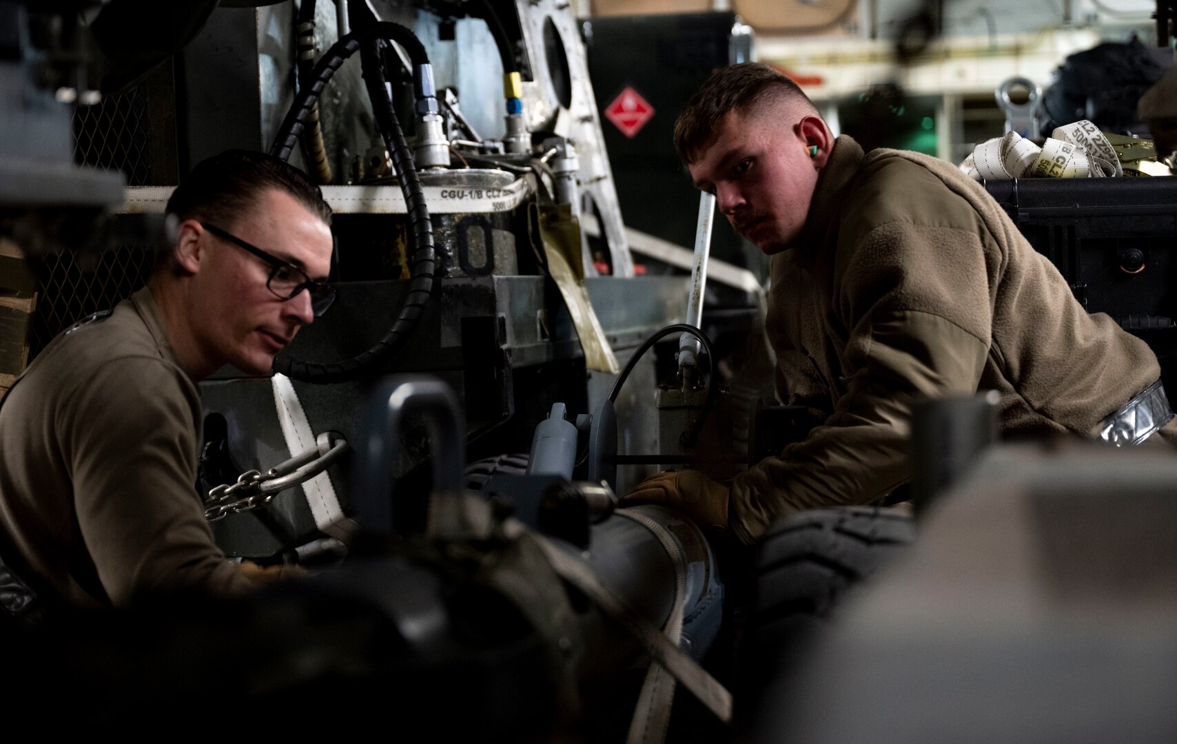 U.S. Air Force Senior Airman Rusty Thompson, 28th Logistic Readiness Squadron air transportation technician (Left) a nd Airman 1st Class Hunter Corcoran, 28th LRS air transportation technician secure cargo onto a C-17  Globemaster III at Ellsworth Air Force Base, South Dakota during a partner integration mission in support of Exercise COPE INDIA 23, April 6, 2023. The U.S. is an Indo-Pacific nation and will remain engaged in the region.  (U.S. Air Force Photo by Airman 1st Class Yendi Borjas)